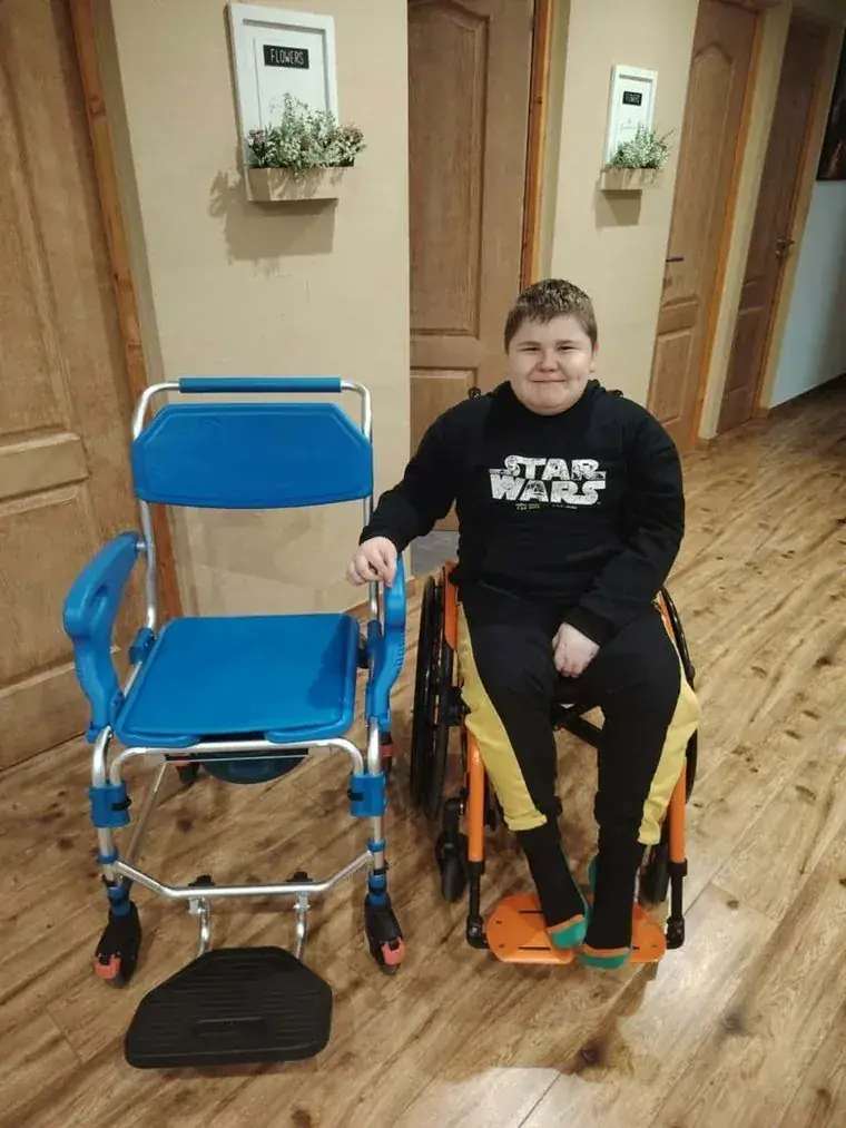 Tibike az új, biztonságos fürdetőszék mellett